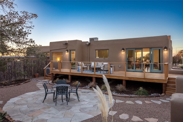 back house at dusk with a patio area