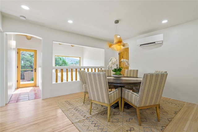 dining area with light wood-type flooring and a wall unit AC