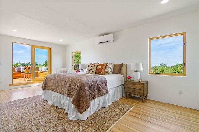 bedroom with light wood-type flooring and an AC wall unit