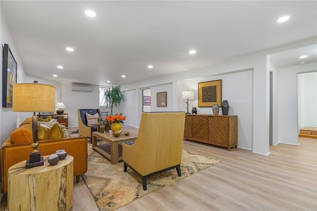 living room featuring light hardwood / wood-style floors and a wall unit AC