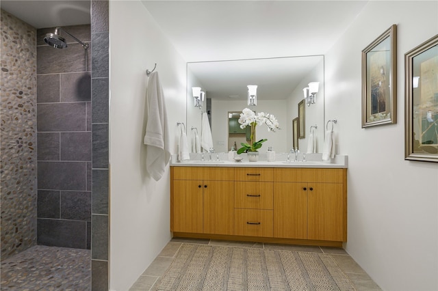 bathroom featuring tile patterned floors, vanity, and a tile shower