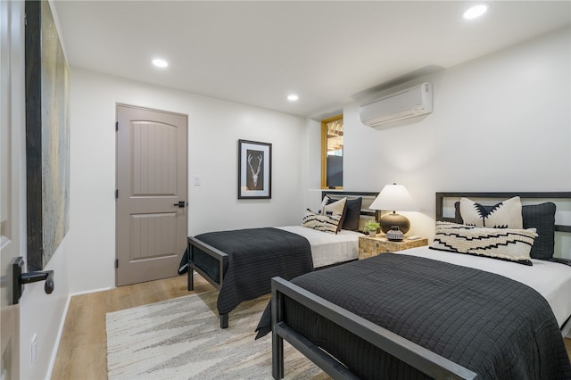 bedroom featuring an AC wall unit and light wood-type flooring