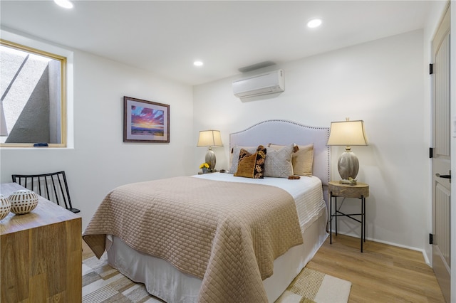 bedroom with light wood-type flooring and a wall mounted AC