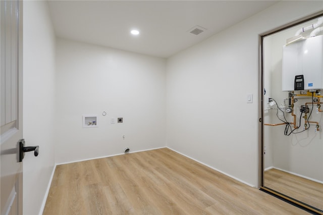 laundry room with hookup for an electric dryer, water heater, gas dryer hookup, hookup for a washing machine, and light wood-type flooring