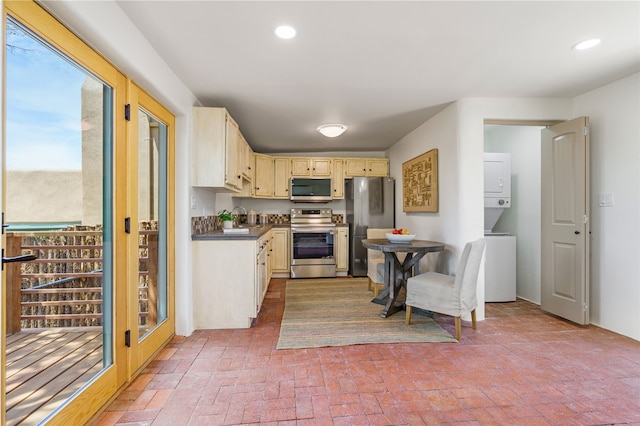 kitchen with sink, stacked washer / dryer, and stainless steel appliances