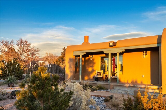 back house at dusk with covered porch