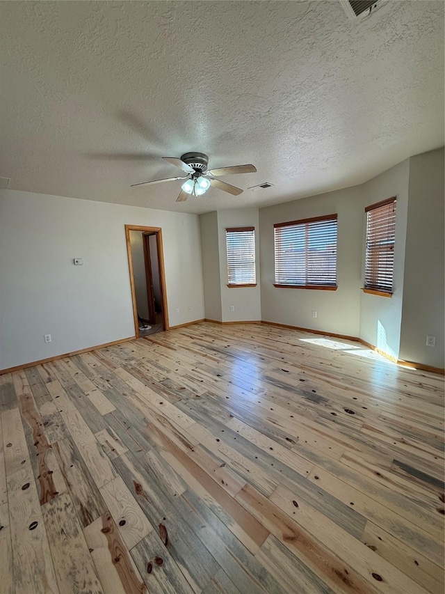 unfurnished living room featuring a textured ceiling, light hardwood / wood-style floors, and ceiling fan