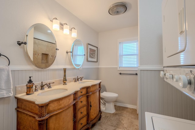 bathroom with vanity, toilet, and wood walls