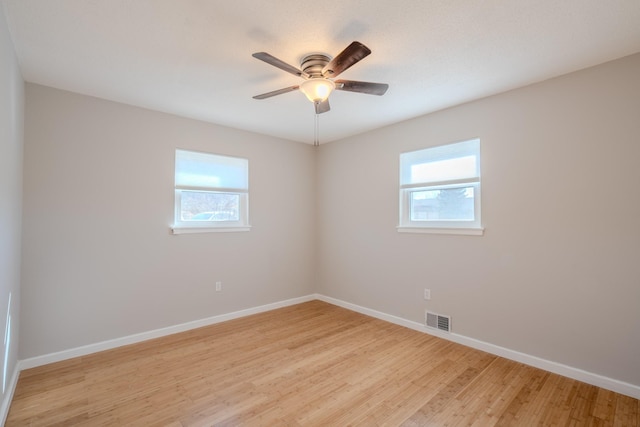 empty room with ceiling fan, a healthy amount of sunlight, and light wood-type flooring