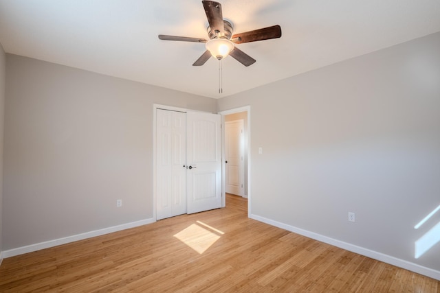 unfurnished bedroom featuring a closet, light hardwood / wood-style flooring, and ceiling fan