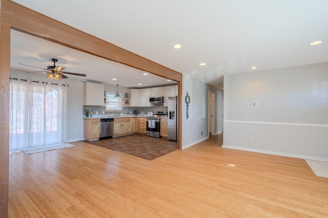 kitchen with backsplash, white cabinets, ceiling fan, wood-type flooring, and stainless steel appliances