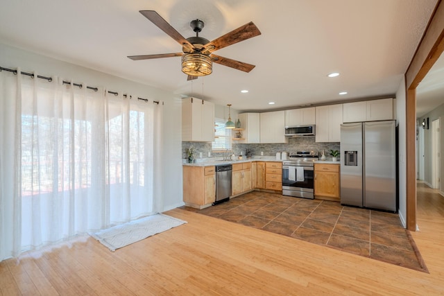 kitchen featuring decorative backsplash, appliances with stainless steel finishes, ceiling fan, light brown cabinets, and decorative light fixtures