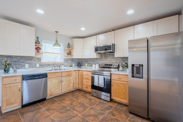 kitchen with tasteful backsplash, sink, decorative light fixtures, and appliances with stainless steel finishes