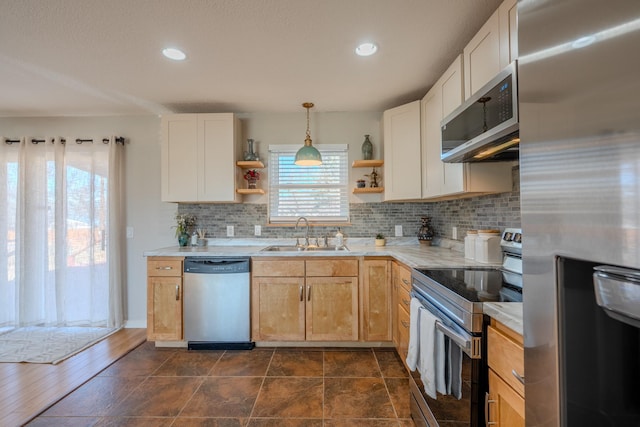 kitchen with light brown cabinets, sink, hanging light fixtures, tasteful backsplash, and stainless steel appliances