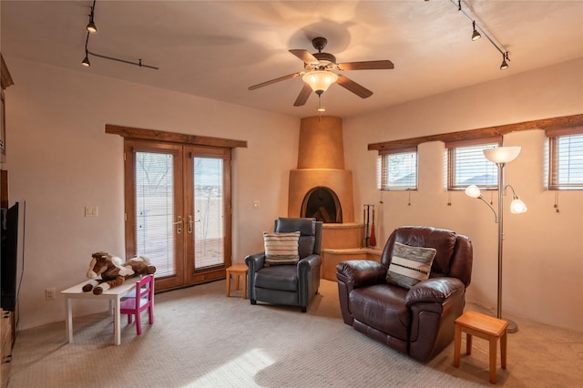 interior space featuring ceiling fan, light colored carpet, and a healthy amount of sunlight