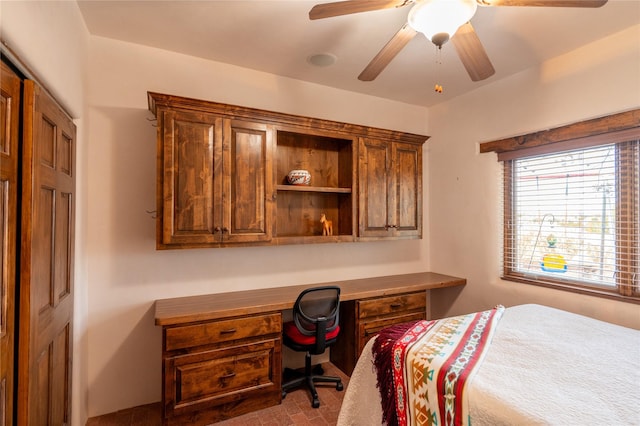 bedroom with built in desk, a closet, and ceiling fan