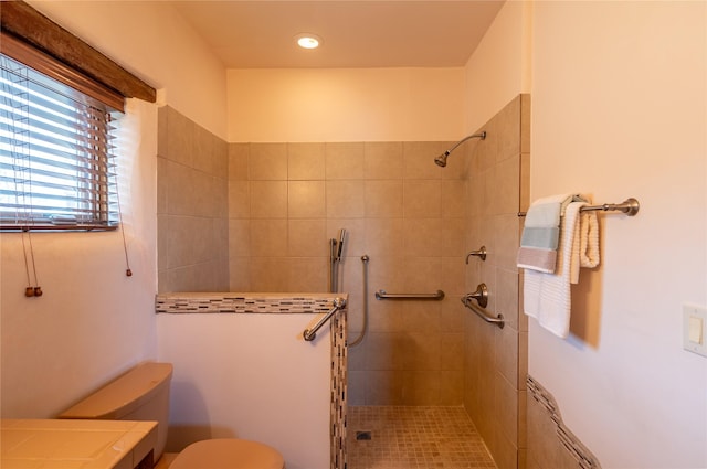 bathroom with tiled shower and toilet