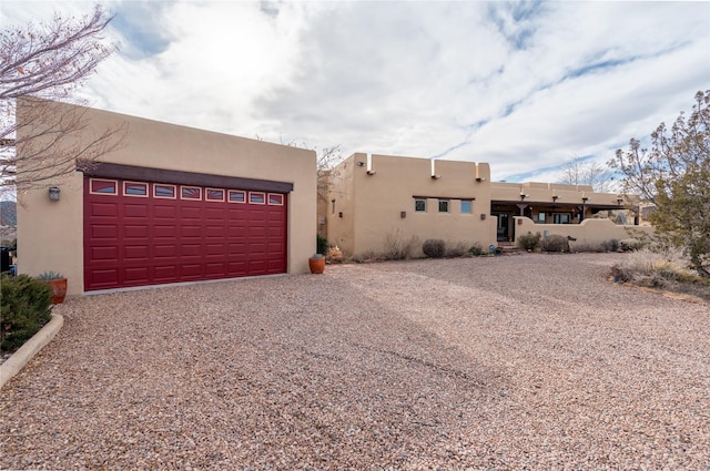 pueblo-style house featuring a garage