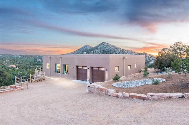 property exterior at dusk featuring a mountain view and a garage