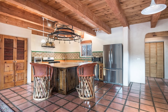 kitchen featuring wood ceiling, stainless steel appliances, decorative backsplash, beamed ceiling, and a center island