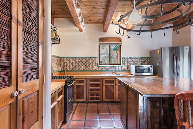 kitchen with appliances with stainless steel finishes, beamed ceiling, decorative backsplash, sink, and wooden ceiling