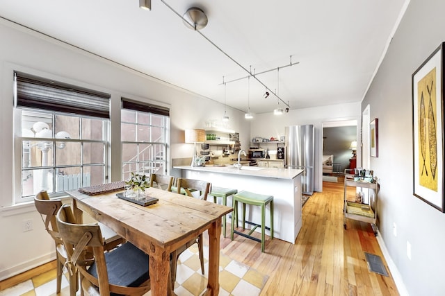 dining space featuring sink and light hardwood / wood-style flooring