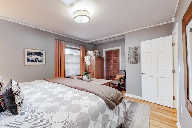 bedroom with hardwood / wood-style flooring and ornamental molding