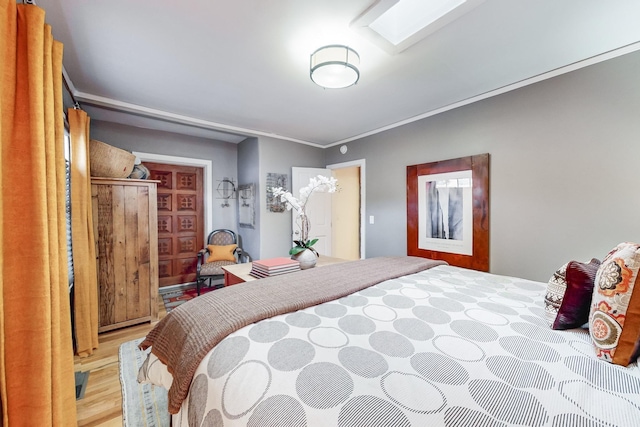 bedroom with light hardwood / wood-style floors and ornamental molding