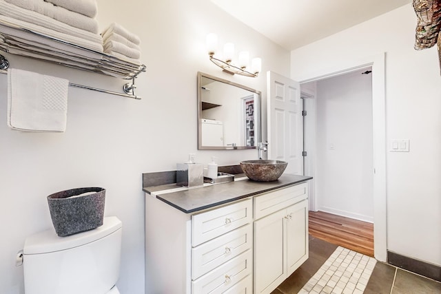 bathroom with tile patterned flooring, vanity, and toilet