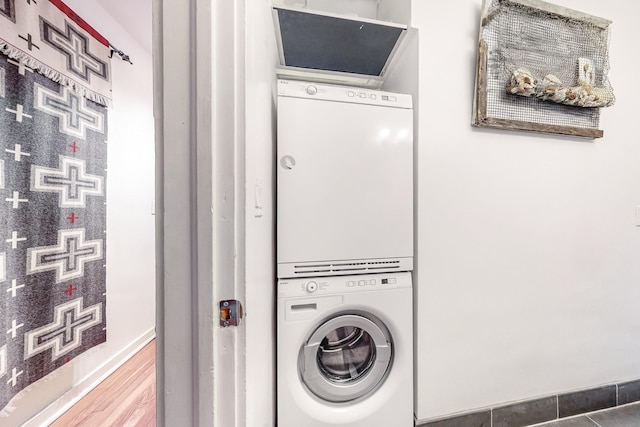 washroom with tile patterned floors and stacked washer / dryer