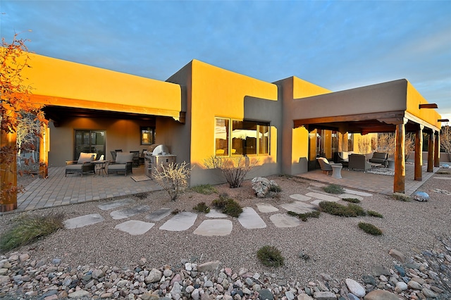 back of house featuring an outdoor living space and a patio