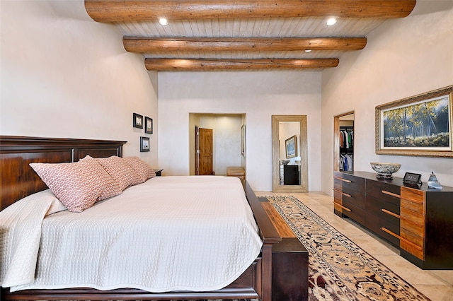 bedroom featuring beamed ceiling, wood ceiling, light tile patterned floors, and a closet