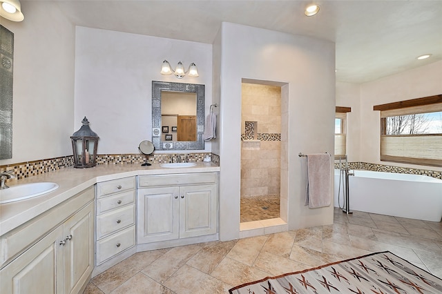 bathroom with backsplash, vanity, and shower with separate bathtub