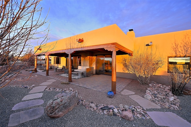 patio terrace at dusk featuring an outdoor hangout area