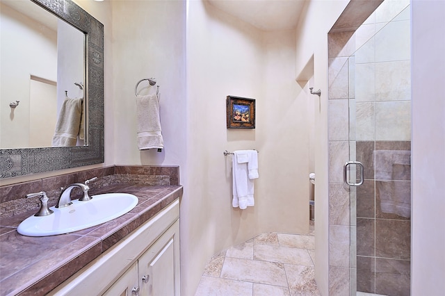 bathroom with vanity, a shower with shower door, and backsplash