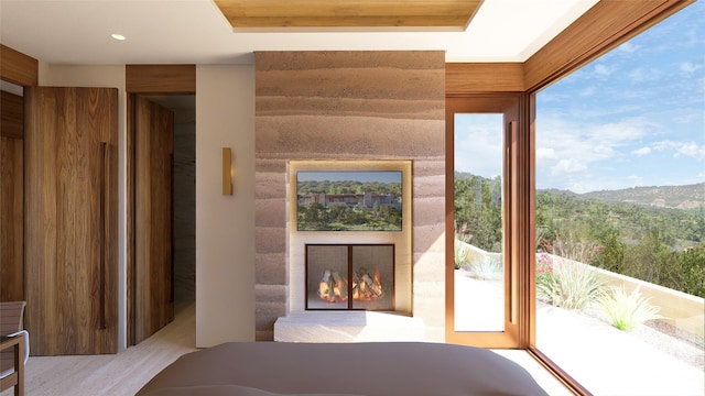 entryway with a fireplace, light wood-type flooring, and a raised ceiling