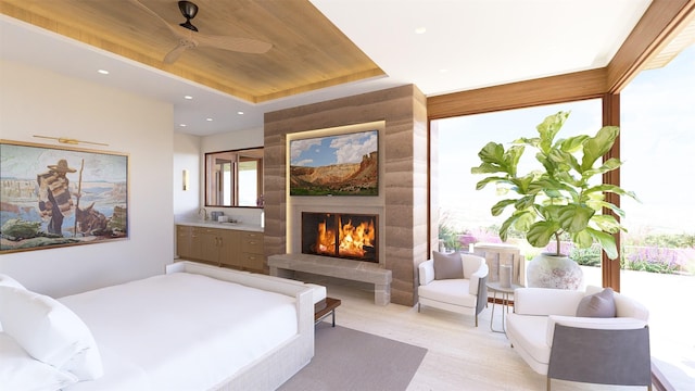 bedroom with ensuite bathroom, a tray ceiling, light hardwood / wood-style flooring, wooden ceiling, and a fireplace