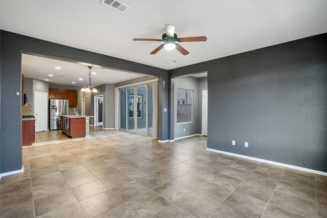 unfurnished living room with sink and ceiling fan with notable chandelier