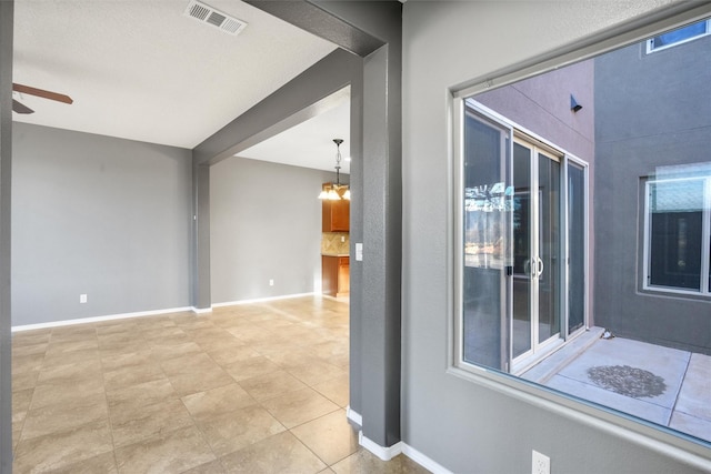 interior space featuring ceiling fan with notable chandelier