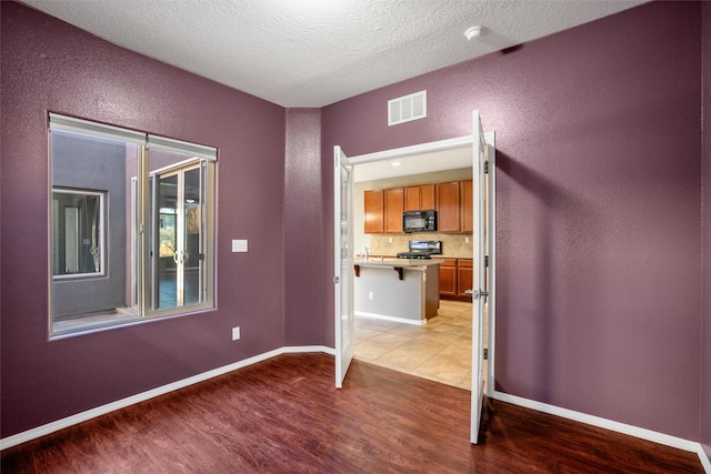 unfurnished bedroom featuring a textured ceiling and light wood-type flooring