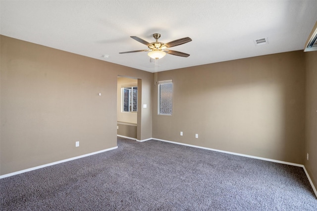 carpeted spare room featuring ceiling fan