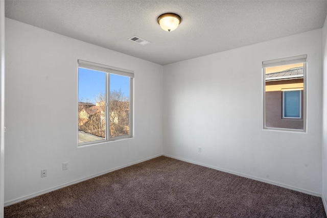 carpeted spare room with a textured ceiling