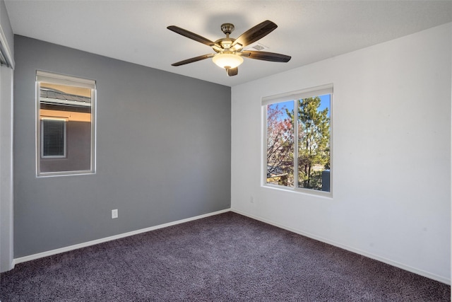 spare room with dark carpet and ceiling fan