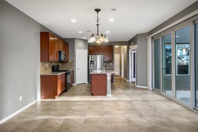 kitchen with pendant lighting, backsplash, black range, an island with sink, and a notable chandelier