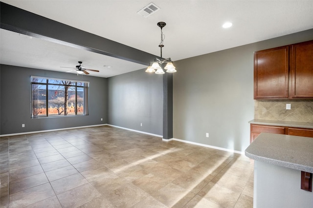 unfurnished dining area featuring beamed ceiling and ceiling fan with notable chandelier