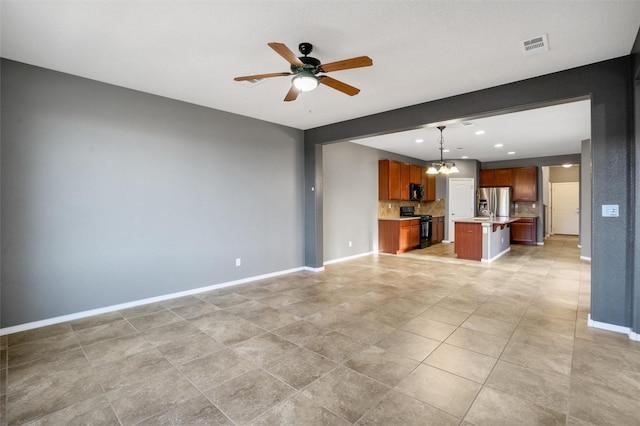 unfurnished living room with ceiling fan with notable chandelier