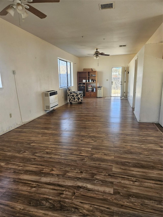 unfurnished living room featuring dark hardwood / wood-style flooring, ceiling fan, and heating unit