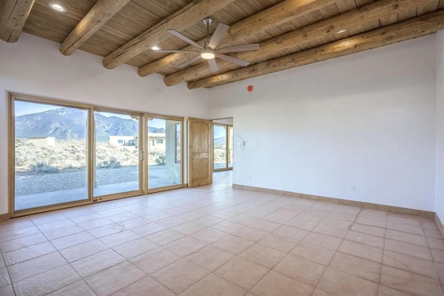 unfurnished room featuring wood ceiling, a mountain view, ceiling fan, light tile patterned flooring, and beam ceiling