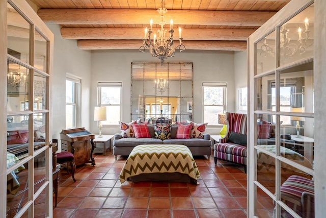 interior space featuring beam ceiling, wood ceiling, a healthy amount of sunlight, and a notable chandelier