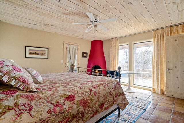 bedroom with ceiling fan, wooden ceiling, and light tile patterned floors